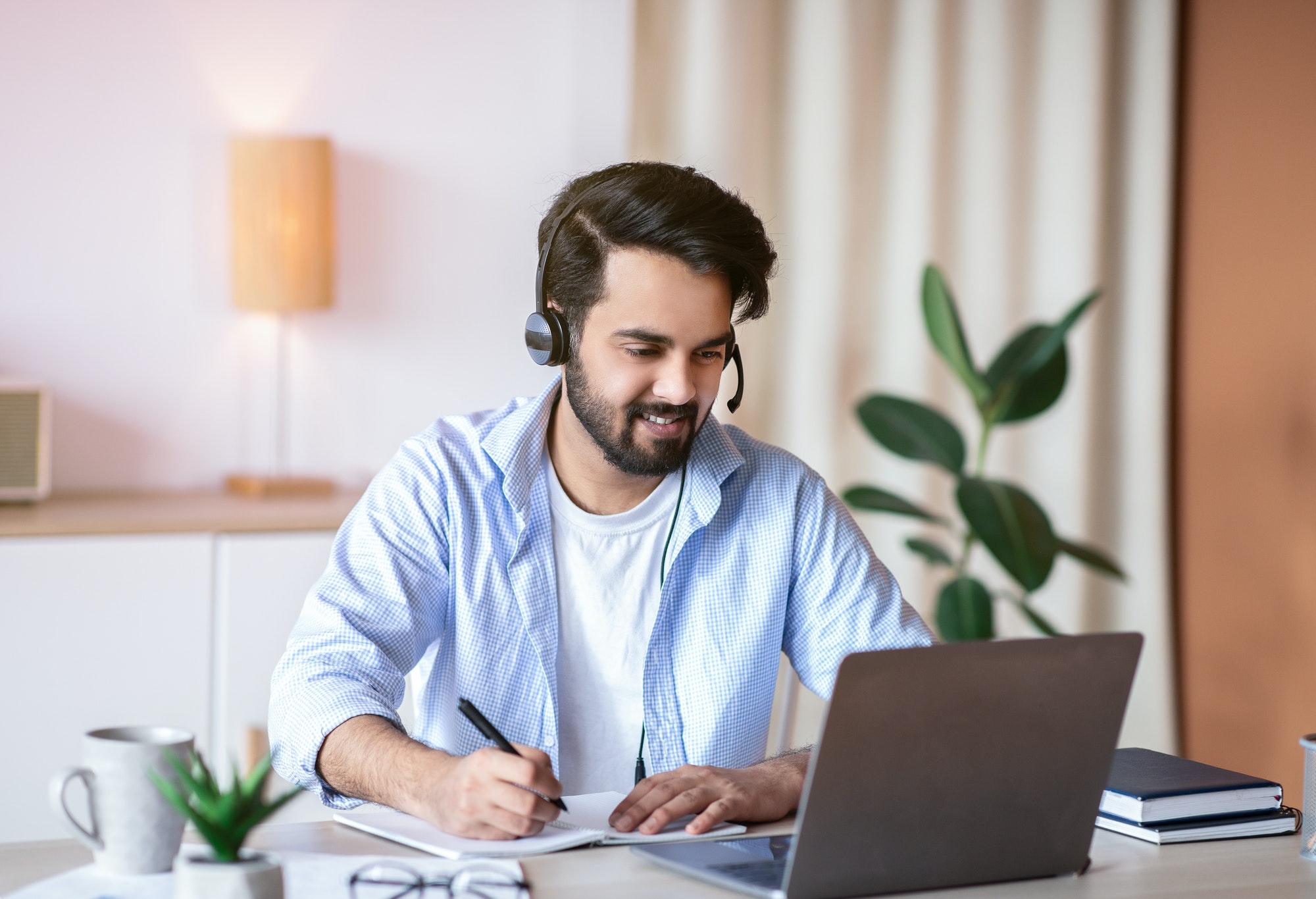 online-education-young-arab-guy-watching-webinar-on-laptop-and-taking-notes.jpg